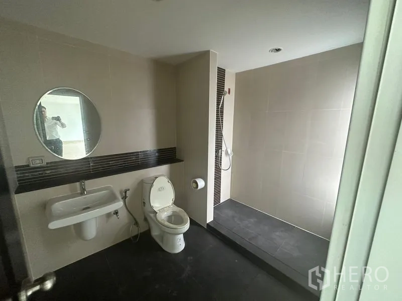 Home Office for rent in Bang Phli, Samut Prakan - Modern bathroom with walk-in shower, toilet and round mirror.