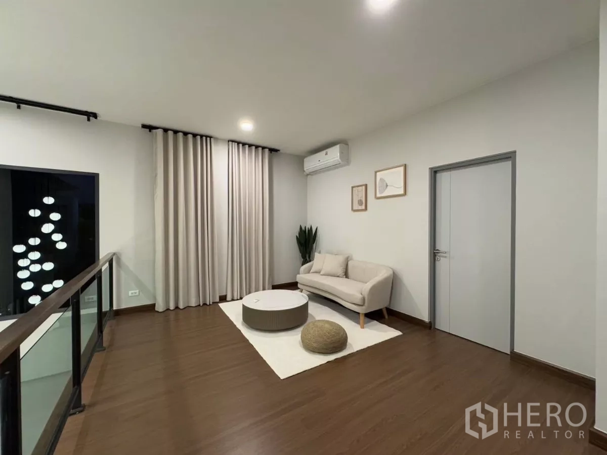 Detached House for rent in Bang Phli, Samut Prakan - Upstairs family area with sofa, round coffee table and glass stair railing