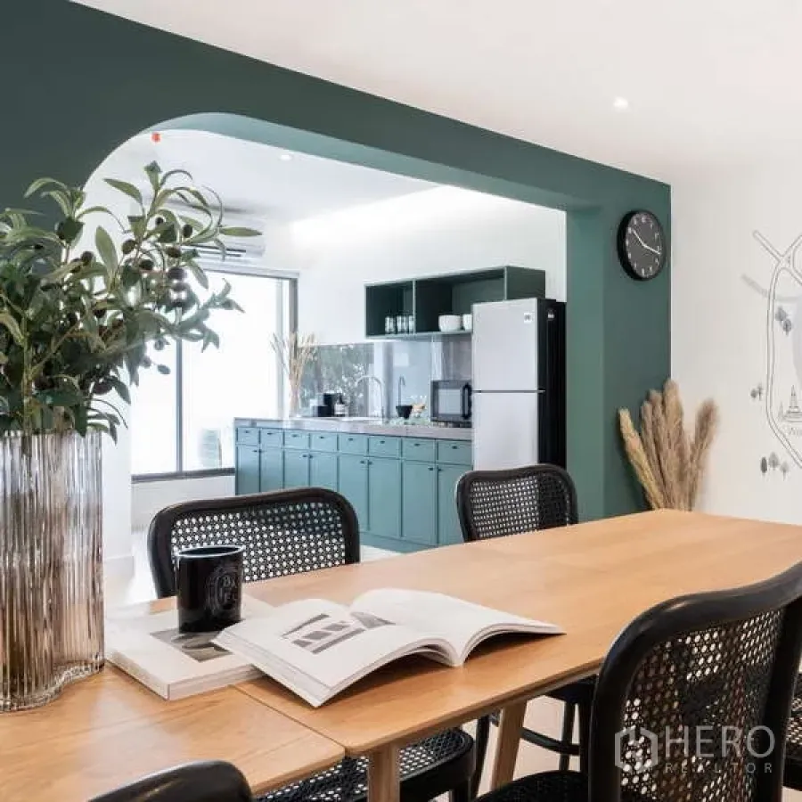 Office Space for rent in Watthana, Bangkok - Open-plan office pantry with green cabinets, archway, and a meeting table filled with natural light.