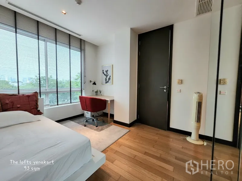 Condominium for rent in Yan Nawa, Bangkok - Second bedroom with floor-to-ceiling windows, study desk, and warm wood floors offering city and tree views.