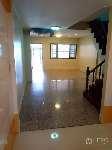 ทาวน์เฮาส์ ให้เช่าในPhra Khanong, Bangkok - ห้องนั่งเล่น–ทานอาหารสว่าง มีหน้าต่างด้านหน้าและบันไดไม้สีเข้ม