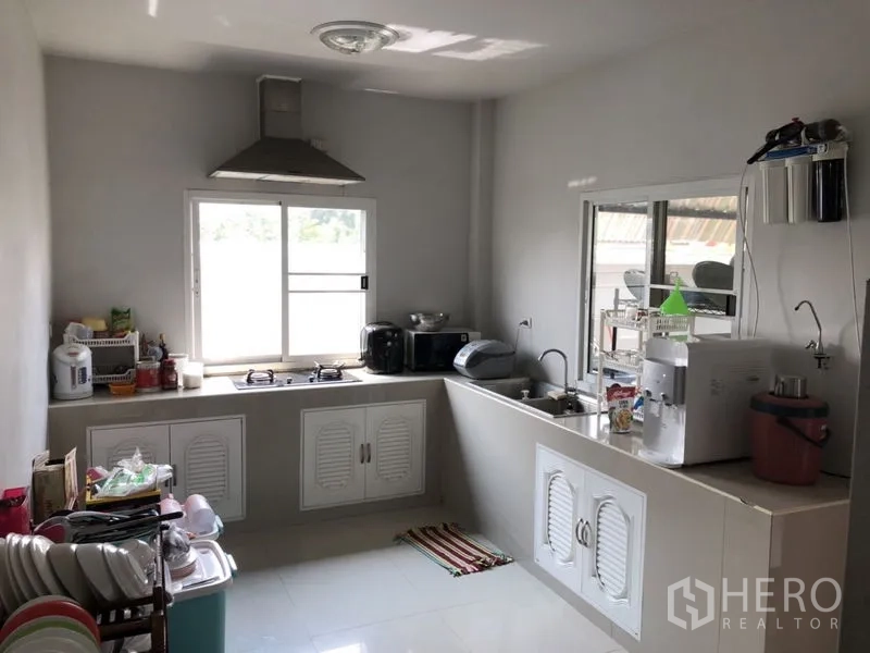 บ้าน ขายในLam Luk Ka, Pathum Thani - ห้องครัวสว่าง เคาน์เตอร์รูปตัวแอล เตาและเครื่องดูดควัน