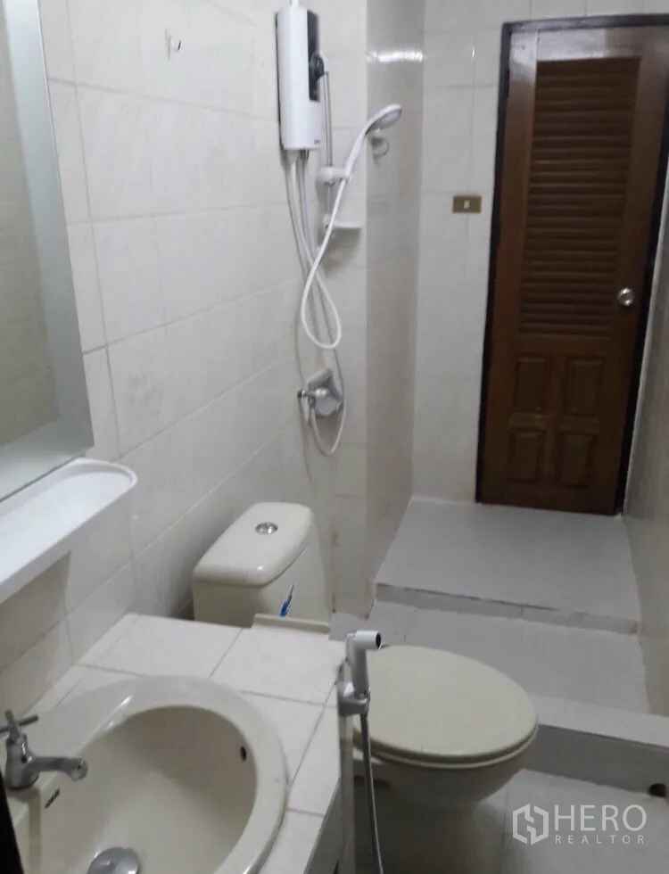 联排别墅 出租在Watthana, Bangkok - 浴室配洗手盆、坐厕、手持喷枪与带热水器的淋浴