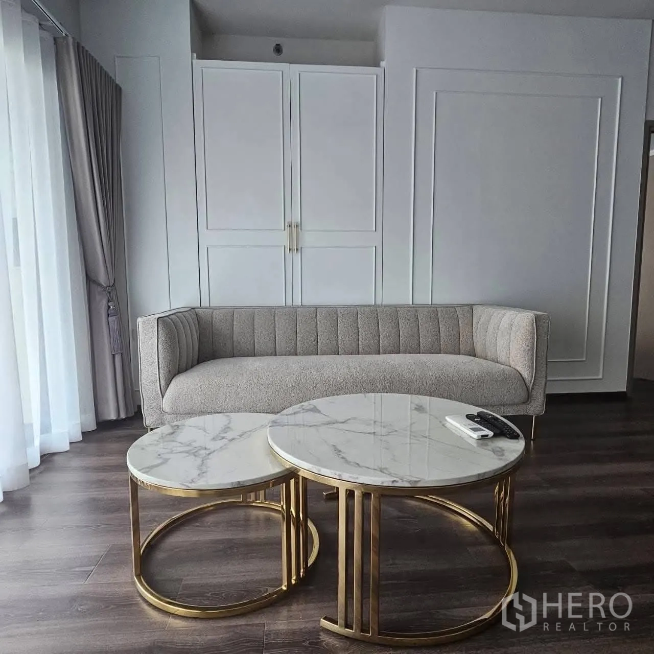 公寓 for rent in Huai Khwang, Bangkok - 明亮客厅，灰色沙发、双圆形大理石茶几与线条装饰墙。