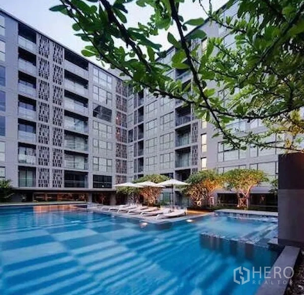 公寓 出售在Watthana, Bangkok - 大型游泳池，周围环绕中高层楼栋与绿化。