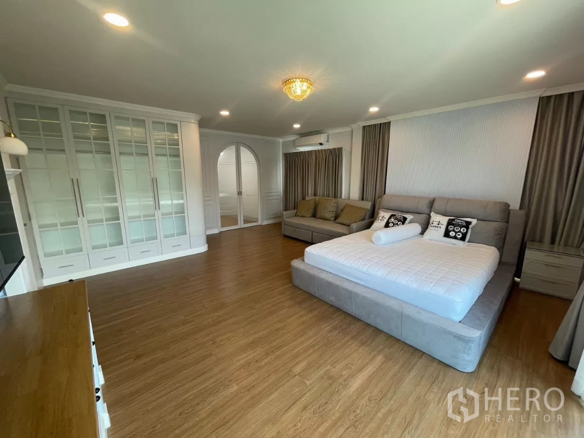 独立式住宅 出租在Bang Phli, Samut Prakan - 主卧套房，大床、通顶衣柜与拱门通向更衣区。