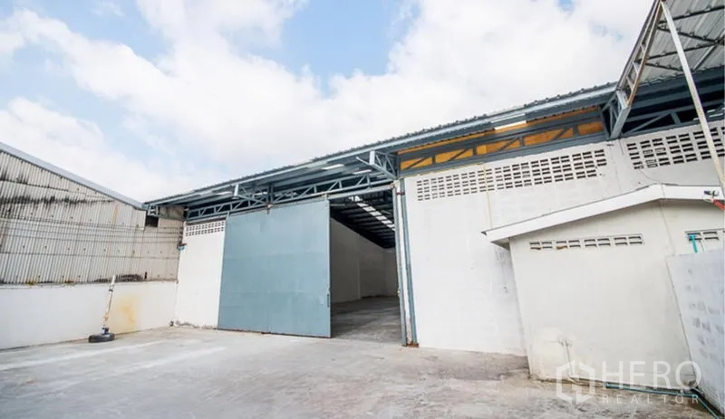 คลังสินค้า ให้เช่าในMueang Samut Prakan, Samut Prakan - ลานขนถ่ายสินค้ากว้าง ประตูบานเลื่อนสีฟ้า ทางเข้าคลุมหลังคาเชื่อมเข้าสู่ตัวโกดังโดยตรง