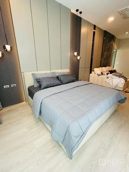 独立式住宅 出租 - 灰色床品卧室，线性装饰墙并设小客厅区。