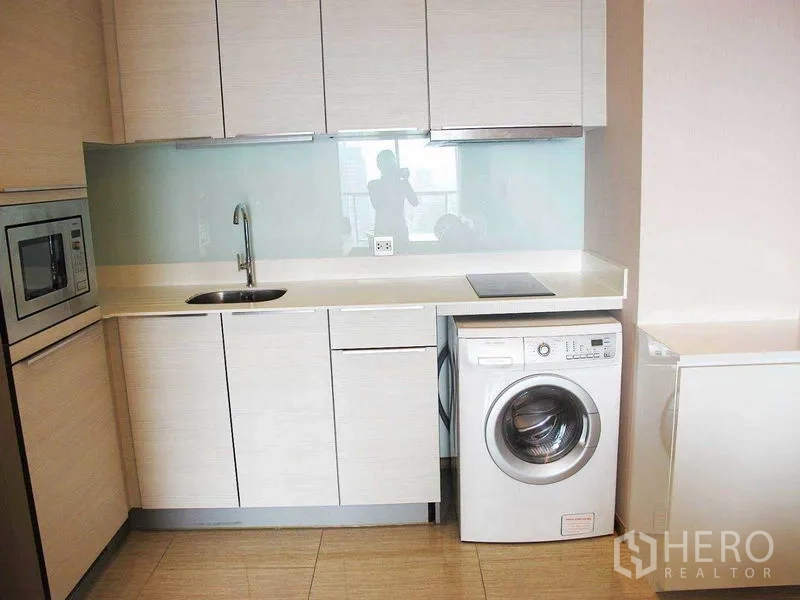 คอนโด ให้เช่าหรือขายในWatthana, Bangkok - ครัวขนาดกะทัดรัด ตู้บิวท์อิน ซิงก์ เตา เครื่องซักผ้า และผนังกระจก