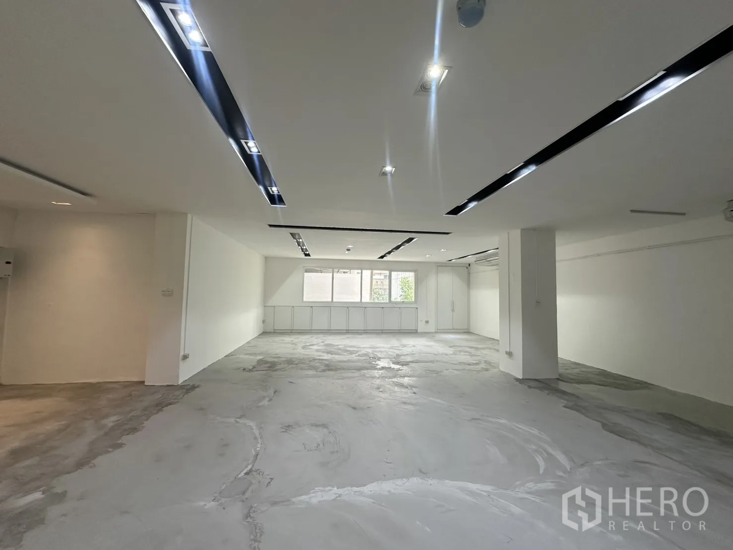 ออฟฟิศ for rent in Pathum Wan, Bangkok - พื้นที่สำนักงานแบบเปิดโล่ง ผนังสีขาว ไฟฝังฝ้า และหน้าต่างด้านท้ายห้อง