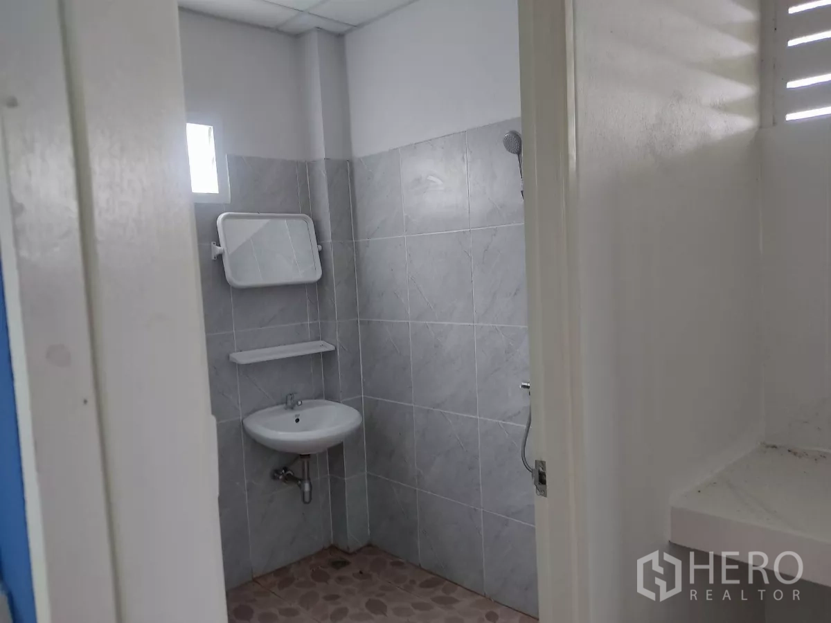 工厂 出售在Khlong Toei, Bangkok - 整洁的瓷砖卫生间，带洗手盆、镜子与手持花洒。