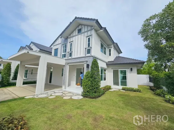 Detached House for rent in Bang Phli, Samut Prakan - Corner plot facade with manicured lawn, carport and landscaped garden at Villagio 3.