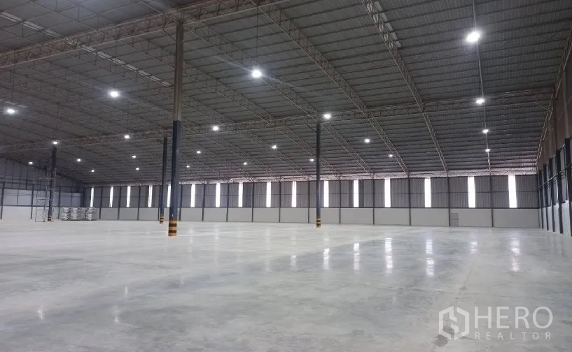 Factory for rent in Si Racha, Chon Buri - Wide clear warehouse bay with smooth concrete floor and bright lighting.