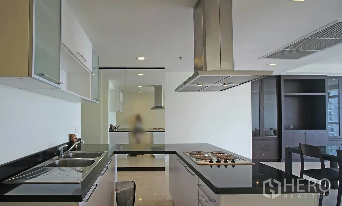 คอนโด ให้เช่าในKhlong Toei, Bangkok - ครัวรูปตัว U เคาน์เตอร์หินสีดำ เตาไฟฟ้า ฮูดดูดควัน และอ่างล้างจานคู่ ในพื้นที่โอเพ่นแปลน