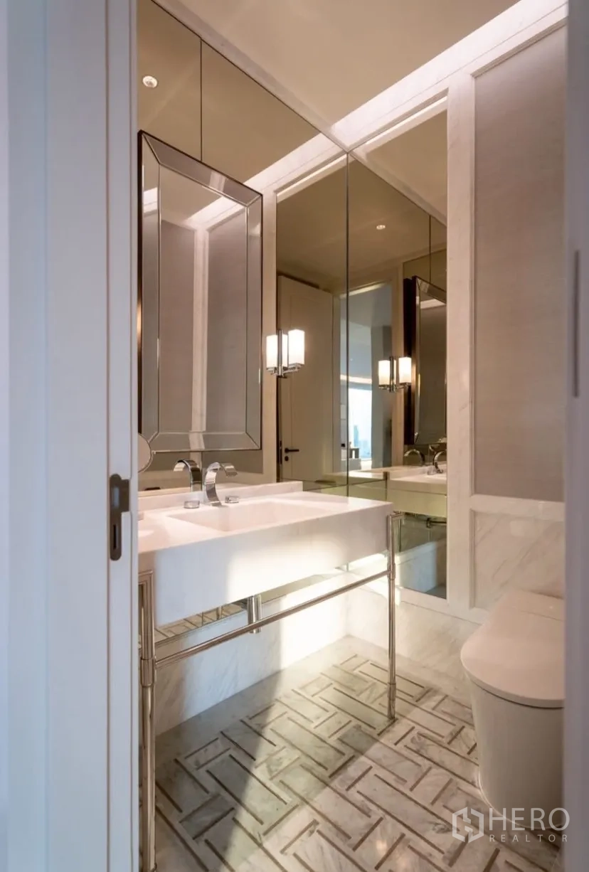 公寓 出租或出售在Pathum Wan, Bangkok - 客用卫生间，大片镜面、白色台盆与现代坐便器。