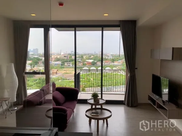 คอนโด ให้เช่าในWatthana, Bangkok - ห้องนั่งเล่นสว่างโปร่งพร้อมหน้าต่างเต็มบาน ระเบียง และวิวเมืองสีเขียวที่คอนโด Mori Haus