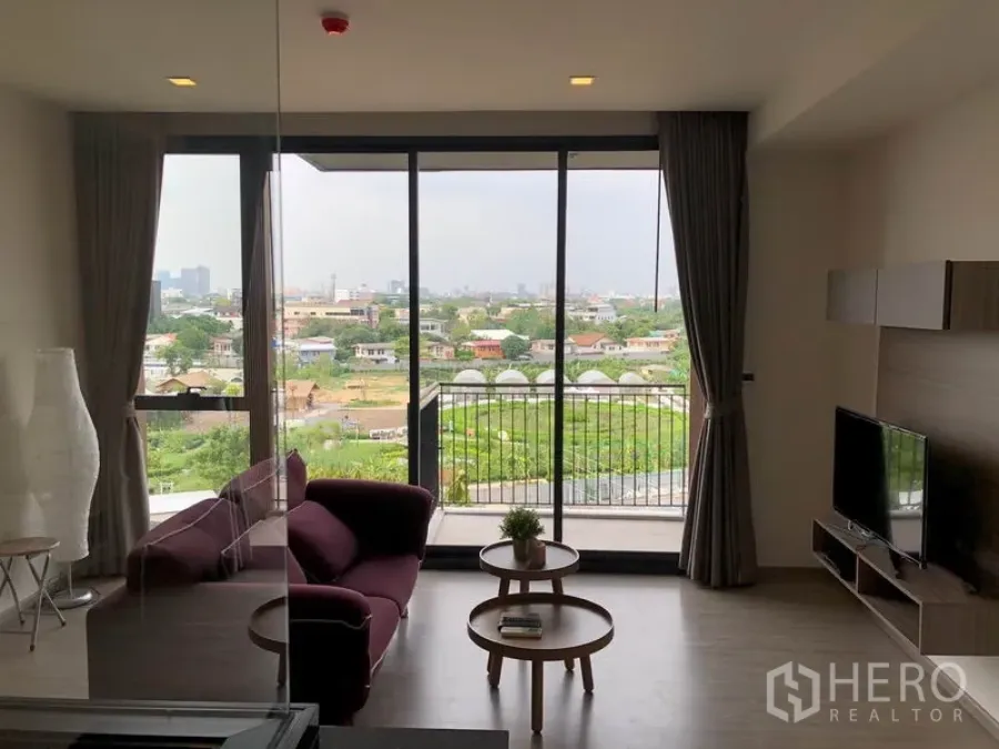 คอนโด ให้เช่าในWatthana, Bangkok - ห้องนั่งเล่นสว่างโปร่งพร้อมหน้าต่างเต็มบาน ระเบียง และวิวเมืองสีเขียวที่คอนโด Mori Haus