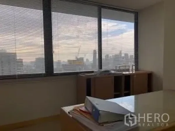 Office Space for rent or sale - Corner office with blinds, desk, and panoramic city views.