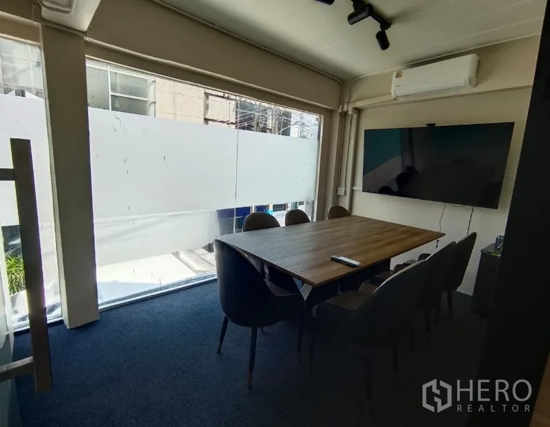 ตึกแถว for rent in Watthana, Bangkok - ห้องประชุมผนังกระจก โต๊ะไม้ เก้าอี้หกตัว และทีวีติดผนัง.