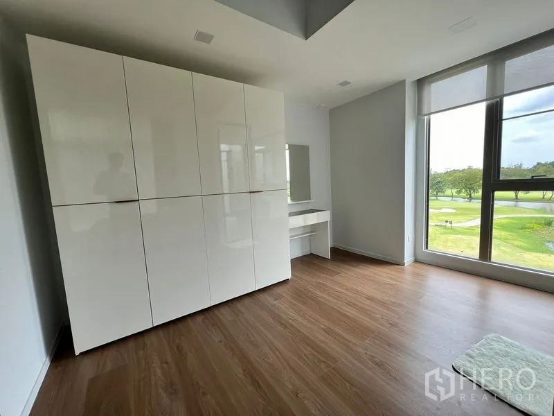 Detached House for rent or sale in Saphan Sung, Bangkok - Wardrobe area with large built‑in closets and a big window facing green parkland.