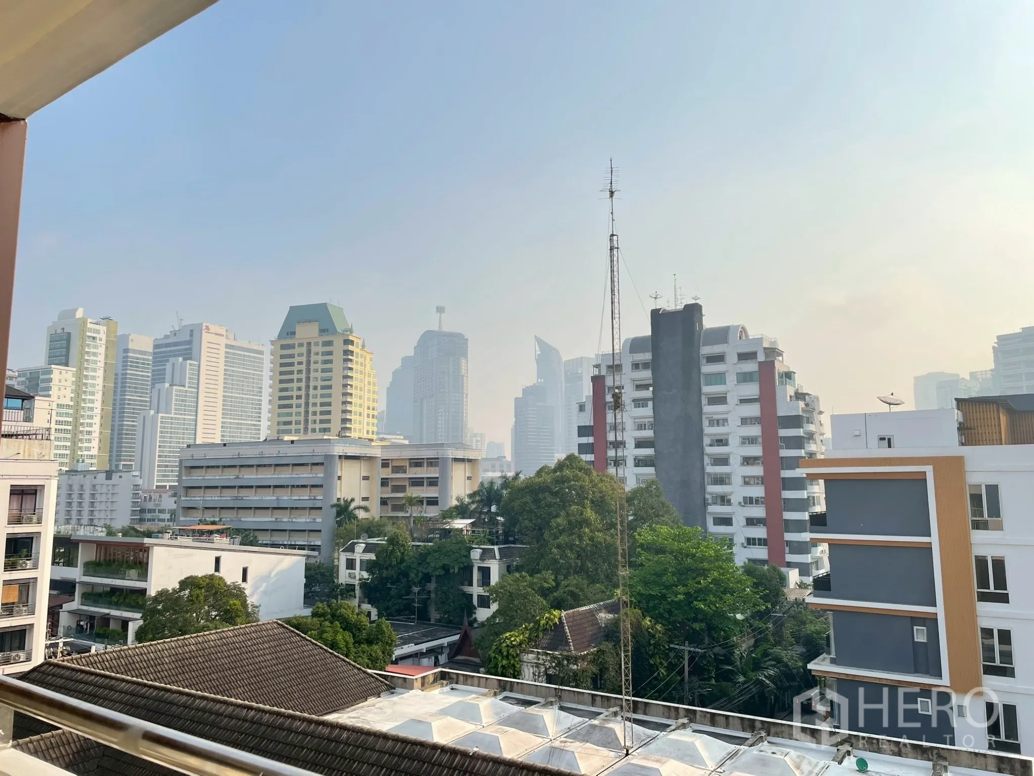 Apartment for rent in Khlong Toei, Bangkok - Balcony view overlooking low-rise buildings and Bangkok skyline.