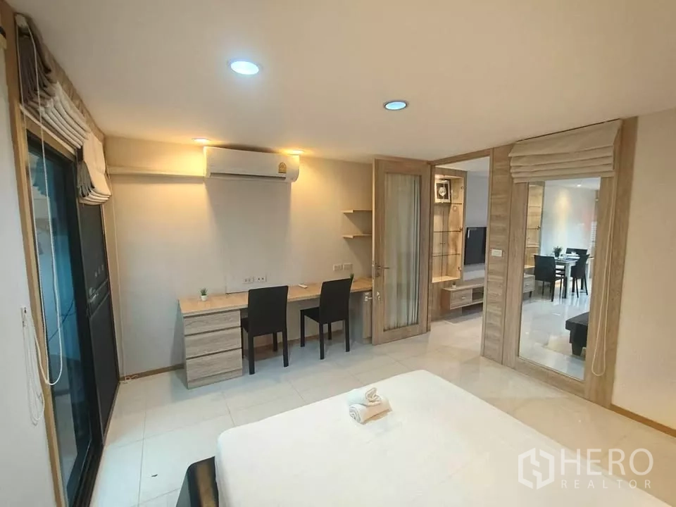 公寓 出租在Khlong Toei, Bangkok - 主卧设双人书桌、空调，并有推拉门通往阳台。