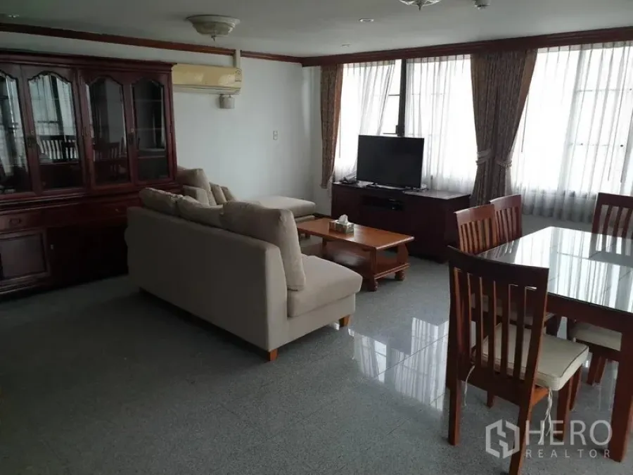 คอนโด ให้เช่าในWatthana, Bangkok - พื้นที่นั่งเล่นและรับประทานอาหารแบบโอเพ่นแปลน โซฟาสีเบจ ทีวี ชุดโต๊ะอาหารไม้ และหน้าต่างบานใหญ่