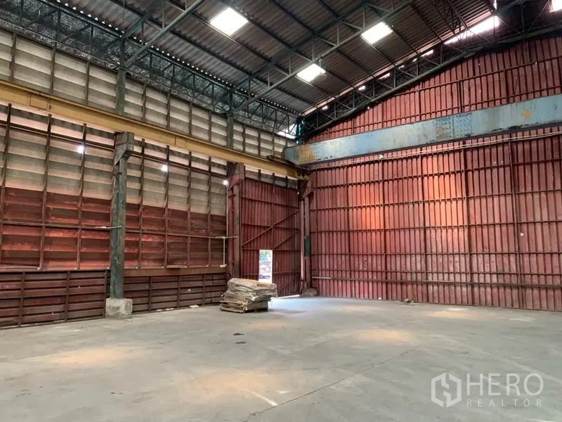 คลังสินค้า ให้เช่าในBang Kho Laem, Bangkok - มุมโกดังแสดงผนังเหล็กสีแดงสูง และพื้นที่ใช้งานปลอดเสา