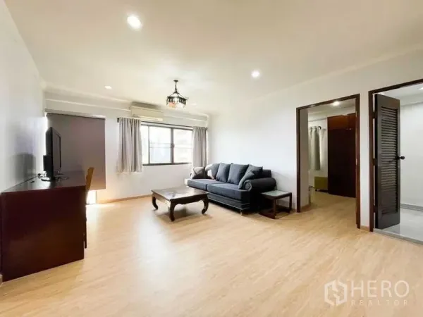 คอนโด ให้เช่าหรือขายในKhlong Toei, Bangkok - ห้องนั่งเล่นกว้าง โซฟา ตู้ทีวี และประตูเชื่อมสู่ห้องนอน