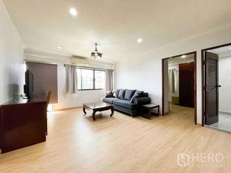 คอนโด ให้เช่าหรือขายในKhlong Toei, Bangkok - ห้องนั่งเล่นกว้าง โซฟา ตู้ทีวี และประตูเชื่อมสู่ห้องนอน