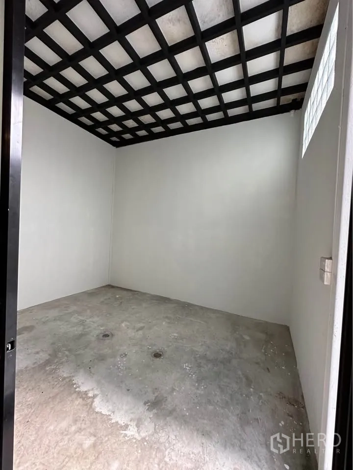 Townhouse for rent in Pak Kret, Nonthaburi - Empty utility or storage room with grid ceiling and concrete floor.