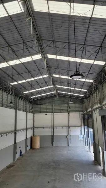 Warehouse for rent in Saphan Sung, Bangkok - High-clear warehouse interior with steel trusses and skylight roof panels.