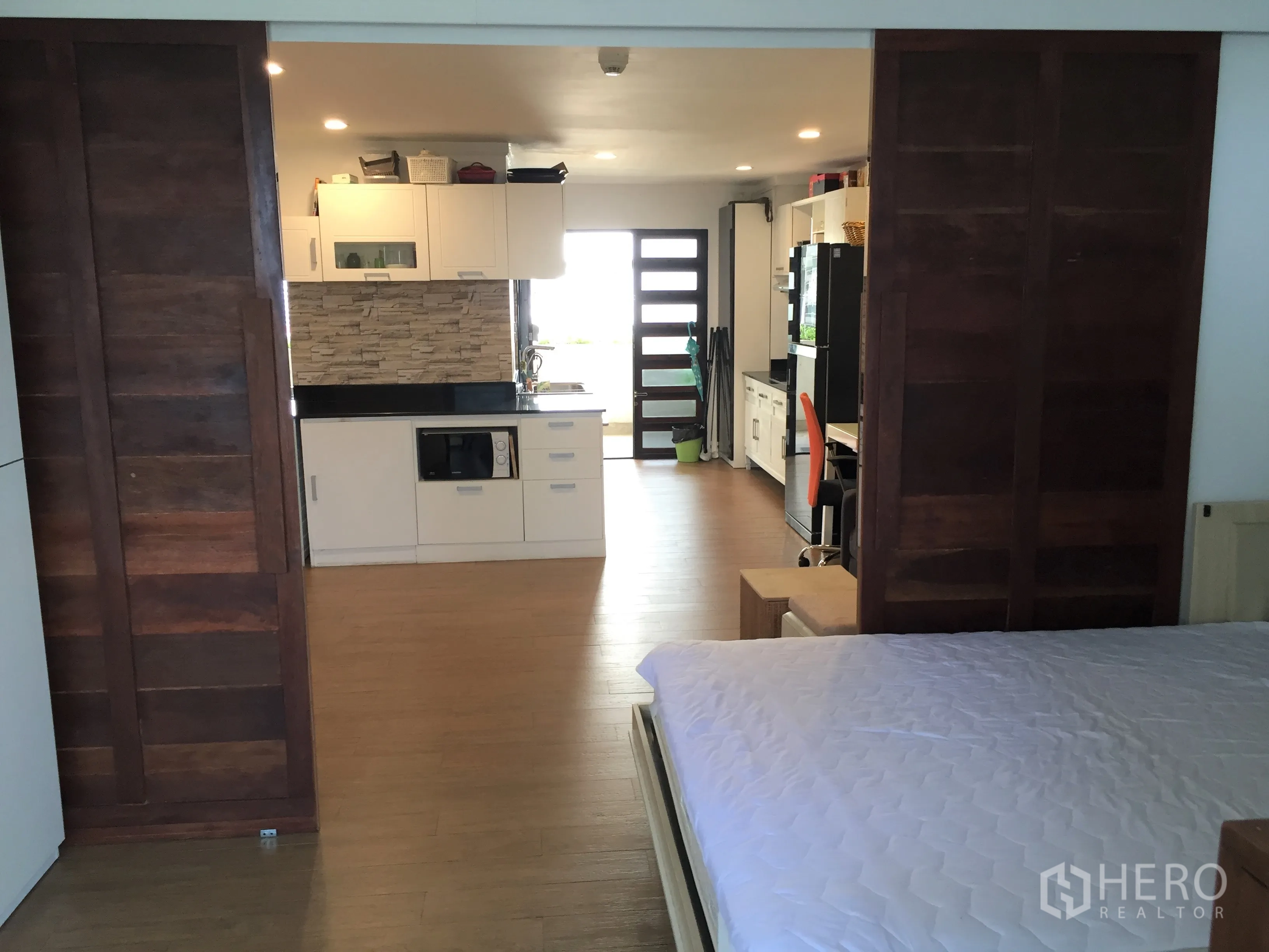 公寓 出租在Watthana, Bangkok - 开放式格局，卧区与厨房以木质推拉门分隔。