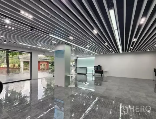 展厅 出租在Bang Rak, Bangkok - 展示厅内部：开放式布局，抛光地面，落地窗与现代线性灯光。