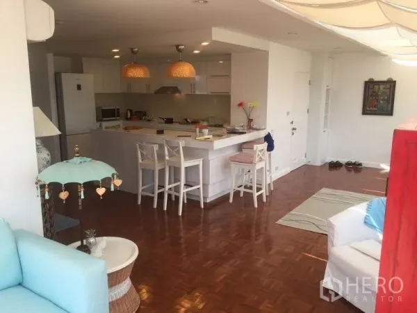 คอนโด ให้เช่าในKhlong Toei, Bangkok - ครัวสีขาวพร้อมไอส์แลนด์และบาร์นั่ง โคมไฟแขวน พื้นไม้ปาร์เกต์ ในพื้นที่นั่งเล่นกว้าง