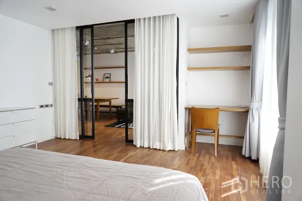 คอนโด ให้เช่าในWatthana, Bangkok - มุมทำงานในห้องนอนพร้อมชั้นลอยและโต๊ะ อยู่ข้างฉากกั้นกระจกสู่โซนนั่งเล่น