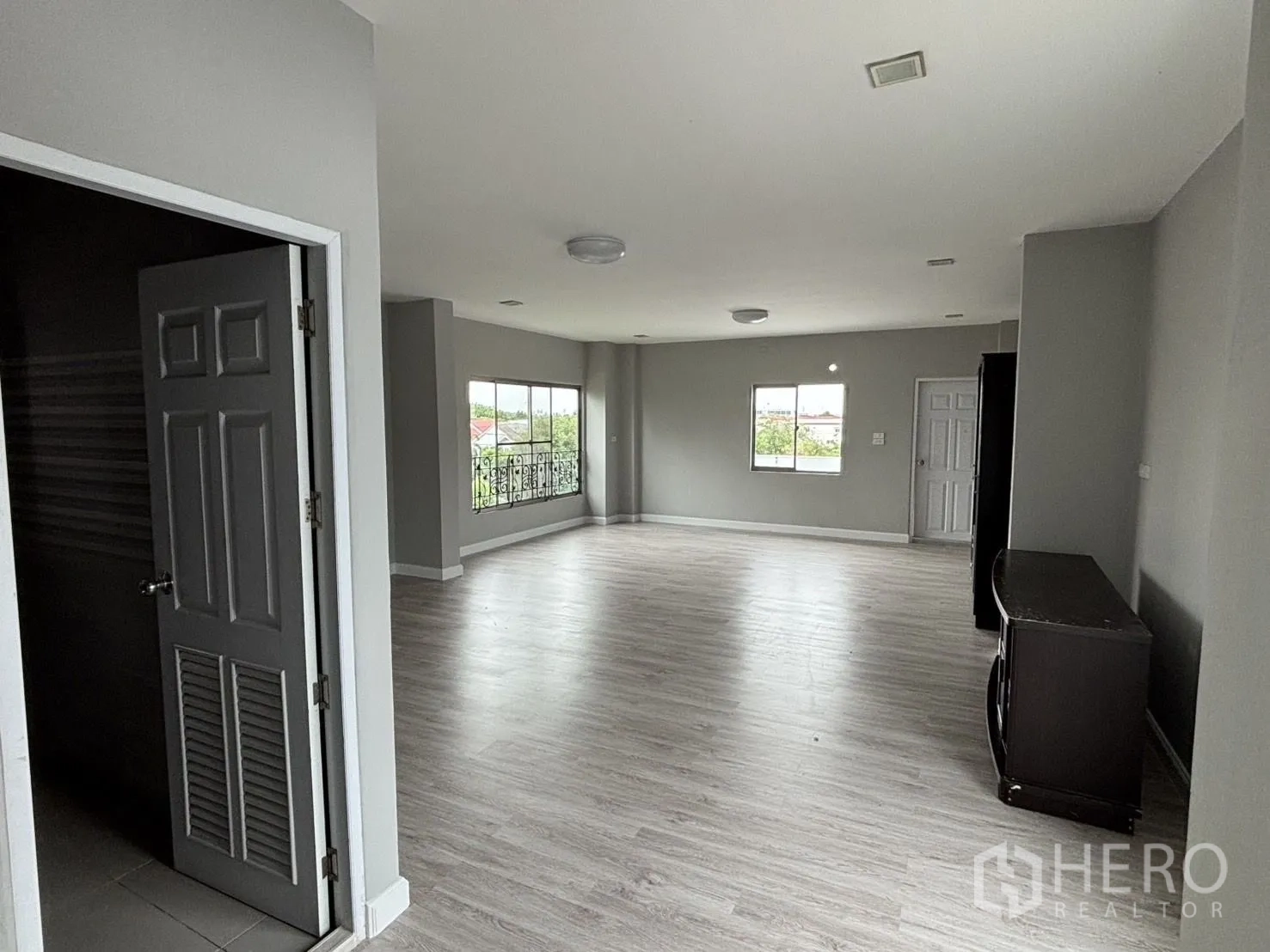 คลังสินค้า ให้เช่าหรือขายในWang Thonglang, Bangkok - ห้องขนาดใหญ่ ผนังสีเทา พื้นลายไม้ และหน้าต่างกว้าง