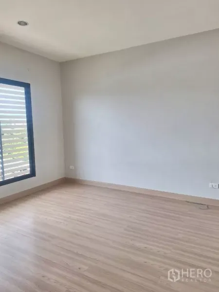 联排别墅 出租在Mueang Samut Prakan, Samut Prakan - 空置卧室，浅木地板与横向百叶窗。