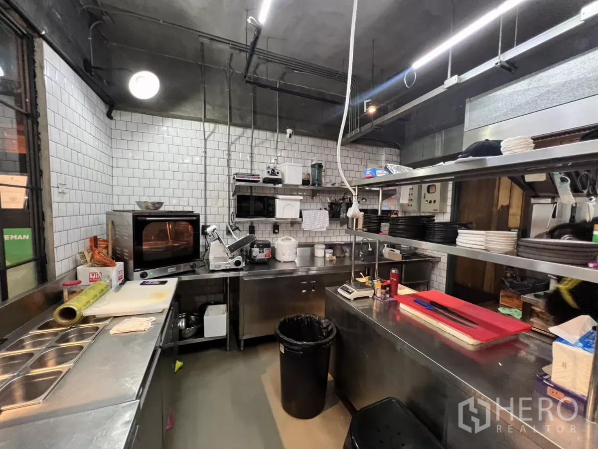 พื้นที่ขายปลีก ให้เช่าในWatthana, Bangkok - มุมมองอีกด้านของครัวกระเบื้องสีขาวพร้อมเคาน์เตอร์เตรียมอาหาร