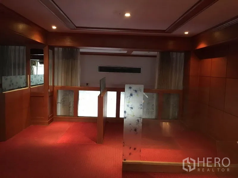 零售空间 出租在Watthana, Bangkok - 夹层/上层空间，磨砂玻璃隔断、木墙板与红地毯。