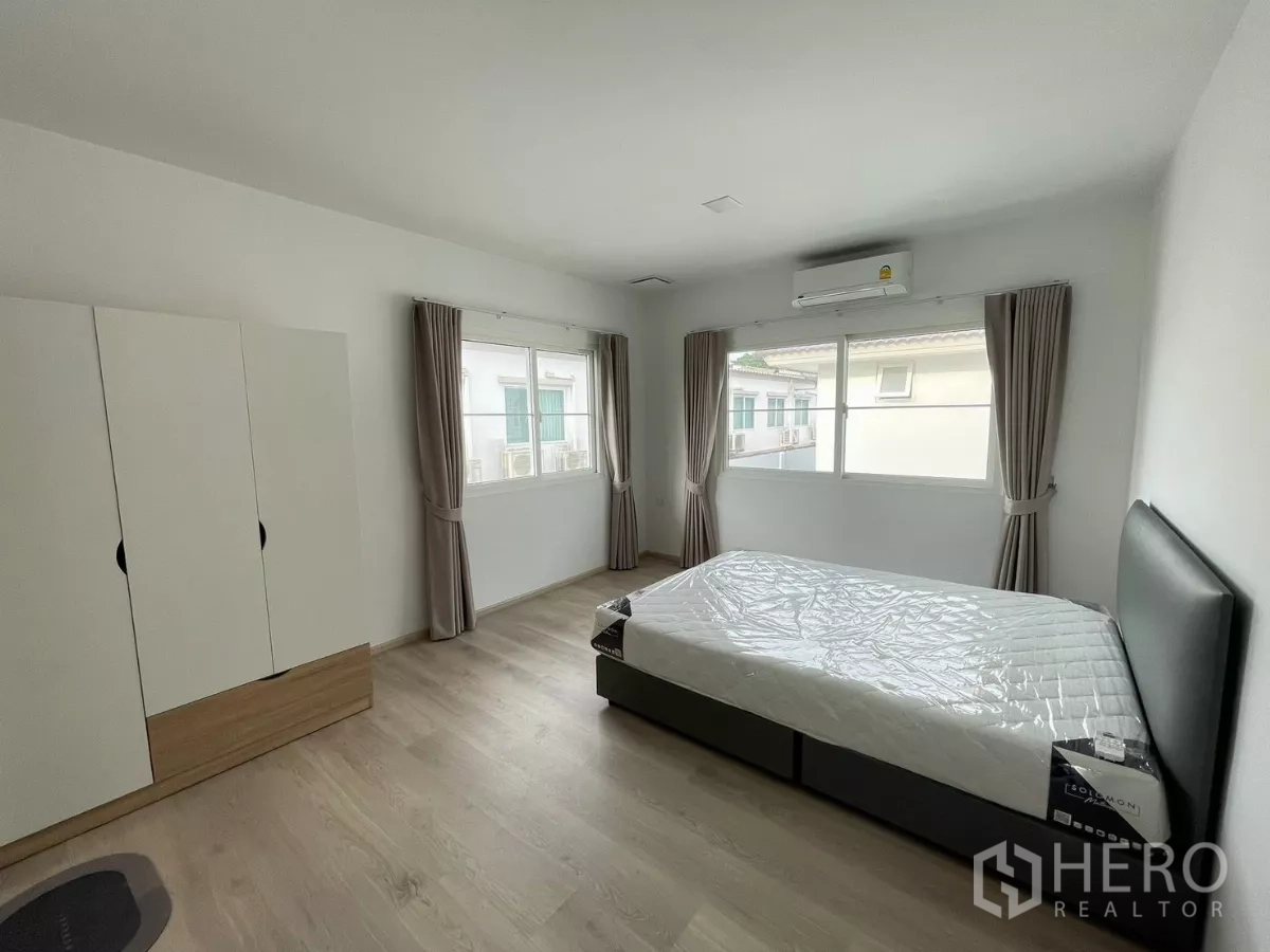 Detached House for rent or sale in Bang Phli, Samut Prakan - Upstairs bedroom with wide windows, wardrobe and air conditioning.