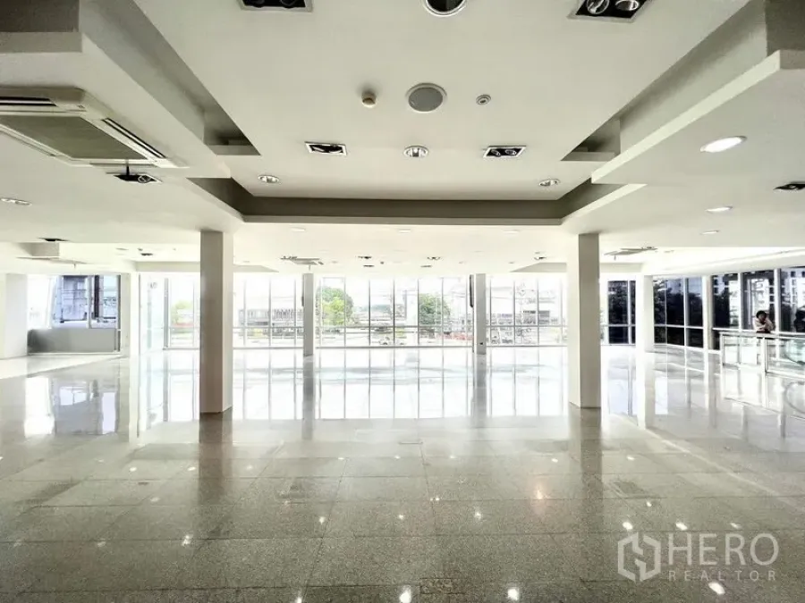 Retail Space for rent in Prawet, Bangkok - Bright open-plan retail floor with polished stone tiles, columns, and full-height windows.