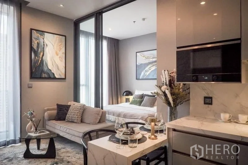 公寓 出租或出售在Huai Khwang, Bangkok - 开放式起居区与小厨房，玻璃推拉门分隔卧室