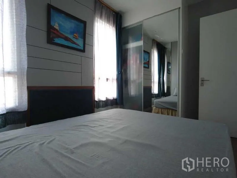 Condominium for rent in Watthana, Bangkok - Bright bedroom with large windows and a mirrored wardrobe.