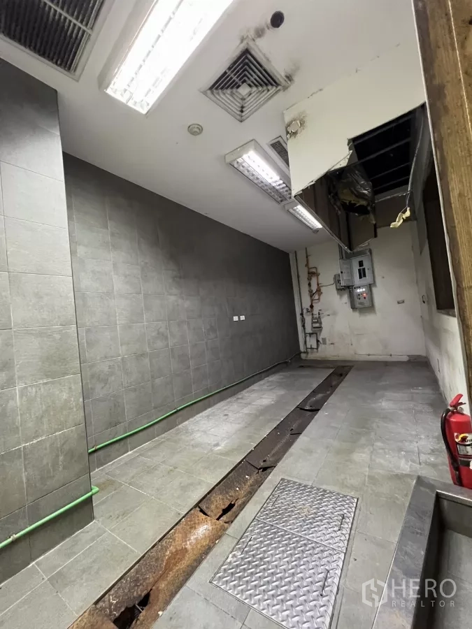 พื้นที่ขายปลีก ให้เช่า - ห้องครัวปูกระเบื้องพร้อมรางระบายน้ำ ฝ้าเพดานมีช่องระบายอากาศ และฝาเปิดตรวจสอบ