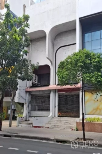 อาคารพาณิชย์ ให้เช่าในWatthana, Bangkok - ด้านหน้าตึกอาคารพาณิชย์หลายชั้น คอนกรีตโค้ง พร้อมประตูม้วนและบันได