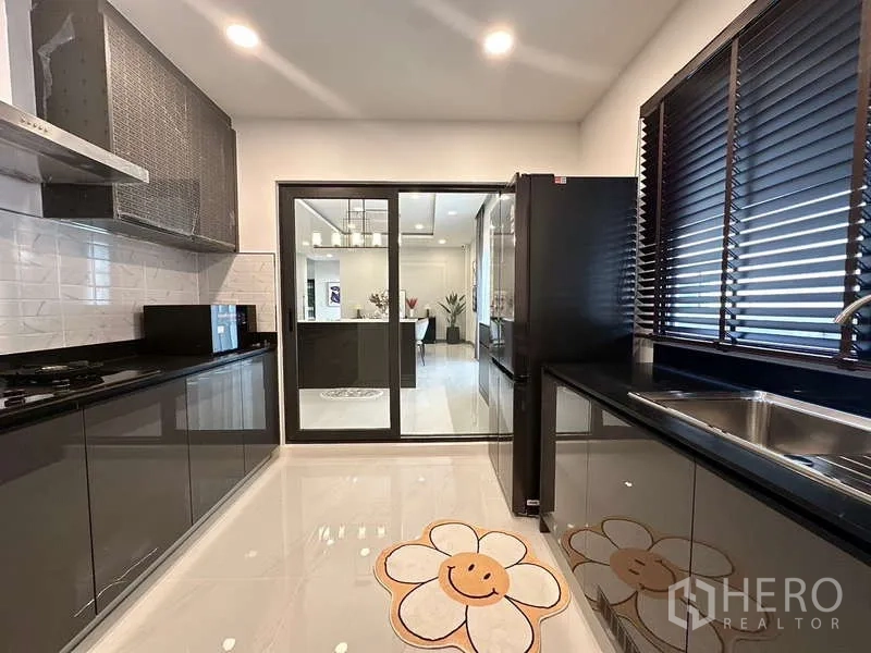 บ้าน ให้เช่าในBang Phli, Samut Prakan - ห้องครัวโมเดิร์น ตู้เงางาม ท็อปสีดำ และประตูกระจกบานเลื่อน