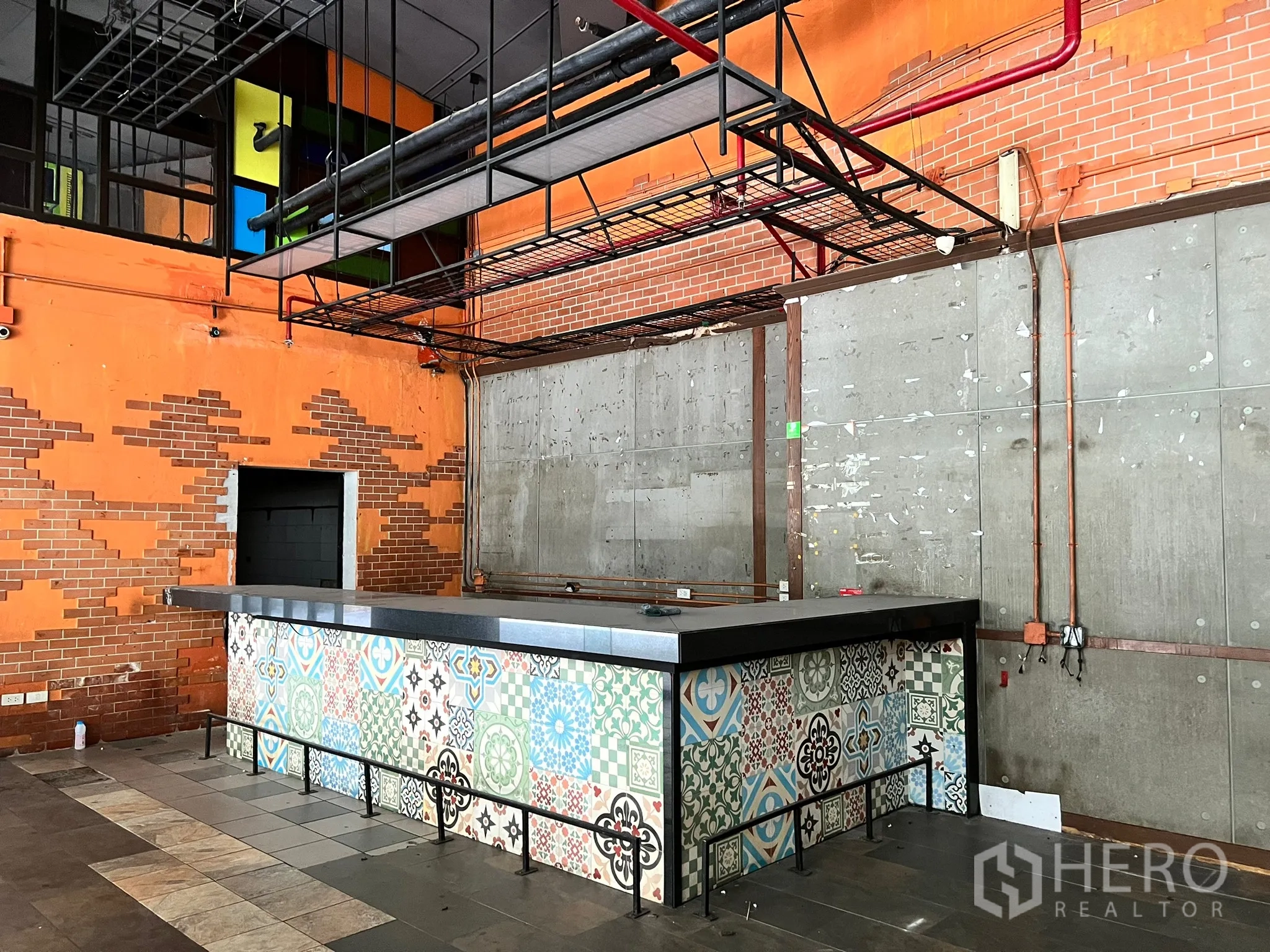 零售空间 出租在Watthana, Bangkok - 工业风零售室内，花纹瓷砖吧台，外露管线与砖混墙面。