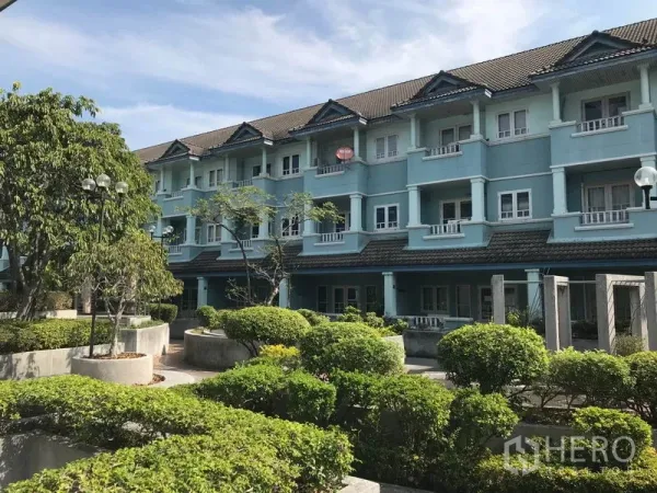 办公空间 出租在Khlong Toei, Bangkok - 低层蓝色建筑外立面，配有绿化庭院和植被。