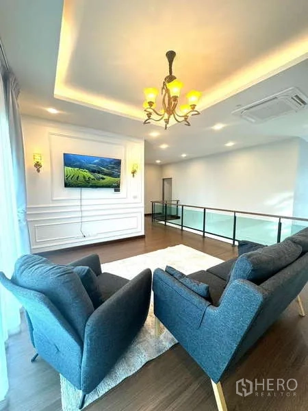 Detached House for rent in Bang Phli, Samut Prakan - Upper family lounge with two armchairs, TV feature wall and glass balustrade